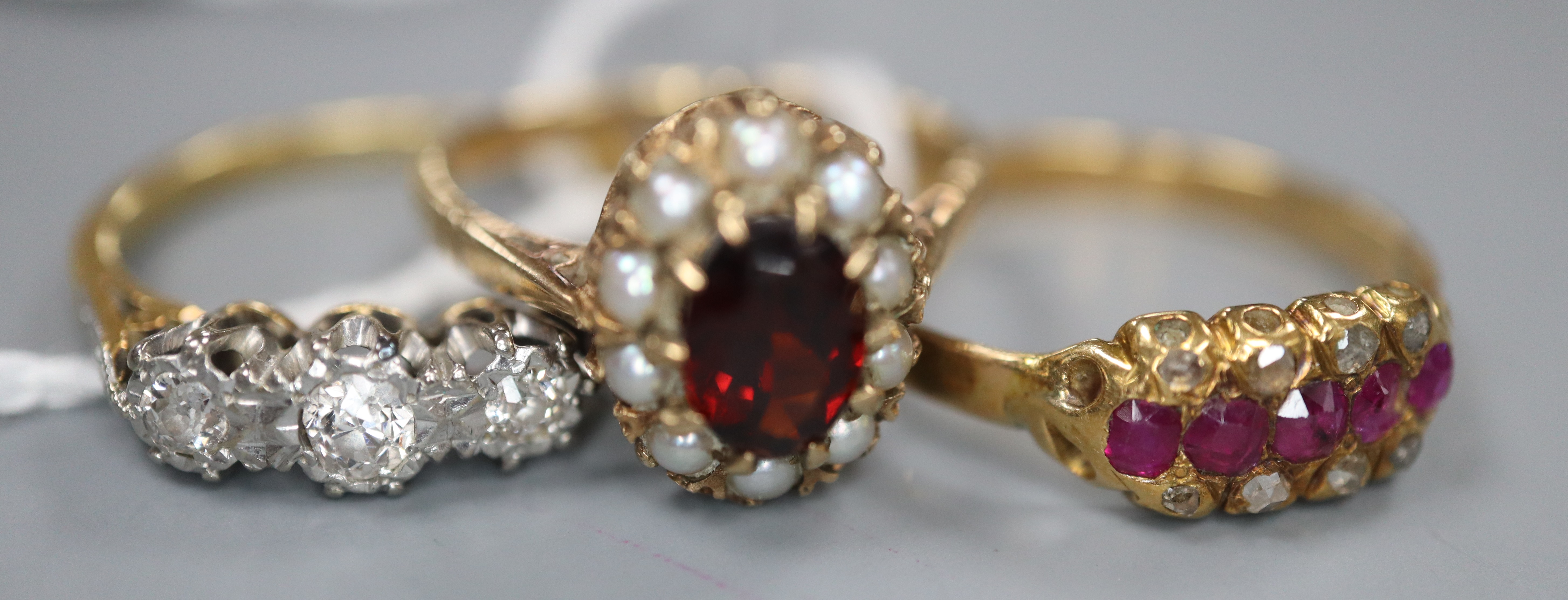 Two 18ct and gem set rings including a three stone diamond ring and a ruby and diamond ring, gross 5.6 grams & a 9ct ring.